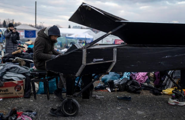 Un refugiado ucraniano toca el piano en la localidad polaca de Medyka. RODRIGO JIMÉNEZ