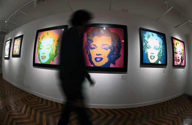 Un visitante pasa junta a varios retratos de Marilyn Monroe, obra del artista estadounidense Andy Warhol, y que forman parte de la muestra "Andy Warhol Super Pop" inaugurada en los útimos días en el Palacio de Santa Bárbara de Madrid. EFE