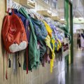 Un pasillo de un centro educativo con las mochilas colgadas fuera del aula.