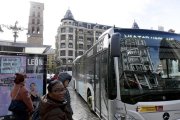 Varias personas esperan a un autobús de transporte público.