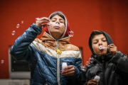 Dos niños refugiados hacen pompas de jabón en el campo de refugiados. POLÍCIA SLOVENSKEJ REPUBLIKY