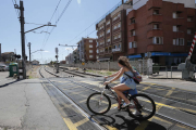 Unos ciclistas atravesando un paso a nivel con barreras ubicado en la localidad de Veguellina de Órbigo. JESÚS F. SALVADORES.