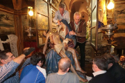 Los 'camareros' de la Virgen descienden a la Señora del Mercado del altar para subirla a su paso