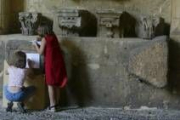 Dos niñas realizan sus dibujos sobre las piedras del claustro de San Marcos el pasado agosto