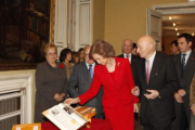 La Reina Doña Sofía observa el atlas durante la presentación
