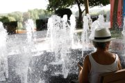 Una mujer sentada ante una fuente en León.