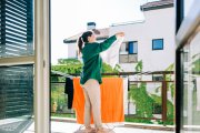 Una mujer tiende la ropa en su balcón