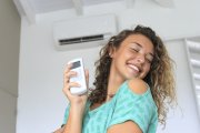 Una chica disfruta del aire acondicionado en su casa