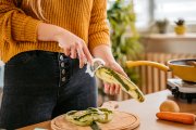 Una mujer pela un pepino