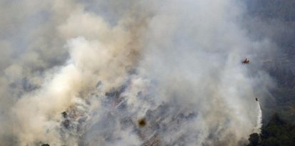Un helicóptero trabaja en la tareas de extinción del incendio forestal de alta intensidad que se inició el lunes en Paüls (Tarragona) y que afecta ya a un total de 3.137 hectáreas, en su mayoría forestales y de ellas más de mil dentro del Parque Natural de Els Ports.EFE/ Quique García.
