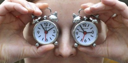 Una mujer muestra dos relojes con el cambio de hora, en una foto de archivo.