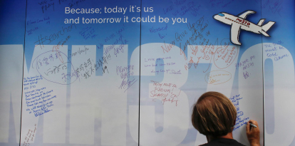 Fotografía de archivo donde una mujer escribe un mensaje dedicado para los pasajeros desaparecidos del avión MH370 de Malaysia Airlines, en el Aeropuerto Internacional de Kuala Lumpur, Malasia, 6 de marzo de 2016. 
                      EFE/ Fazry Ismail