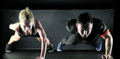 Una mujer  y un hombre realizan ejercicio intenso.