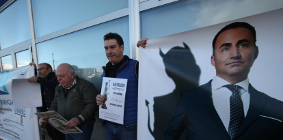 Afectados por la macroestafa, con una foto del cabecilla del grupo en una de las manifestaciones de protesta celebradas en Ponferrada.