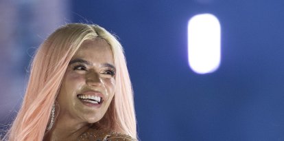 La  cantante colombiana Karol G luce una piedra preciosa en una de sus piezas dentales. EFE/Orlando Barría