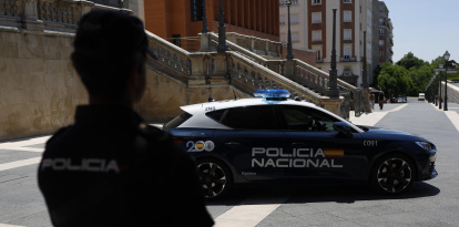 Un agente y un coche patrulla de la Policía Nacional en Madrid. EFE/ MARISCAL.