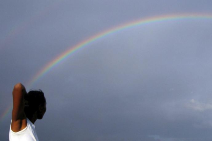 Una mujer observa un arcoiris.