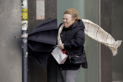 Una mujer se resguardaba de la fuerza del viento en A Coruña durante el paso de la borrasca Karlotta.