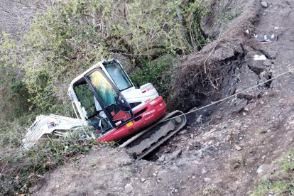 Una retroexcavadora del servicio de Medio Rural de Ponferrada sufre un accidente en un camino de Montes de Valdueza