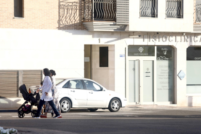 Unas mujeres pasean con un carrito de bebé frente al edificio donde se encontró el cuerpo del menor.