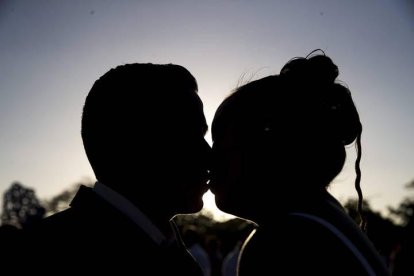 Una pareja se besa durante una ceremonia.