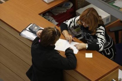 Una mujer atiende al público en una administración.