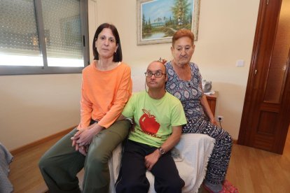 José Antonio Núñez, ciego de cataratas y con síndrome de Down, entre su hermana Mari Carmen y su madre Lucía.