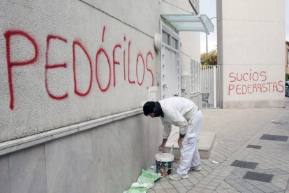 Imagen de archivo de un operario que borra una pintada contra la pederastia en Granada.