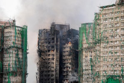 Una nube de humo sale desde uno de los edificios calcinados en Hong Kong, con decenas de víctimas mortales.
                      EFE/EPA/LEUNG MAN HEI.
