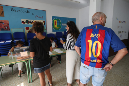 Un aficionado del Barcelona acude a votar con la camiseta de Mesi. L. DE LA MATA