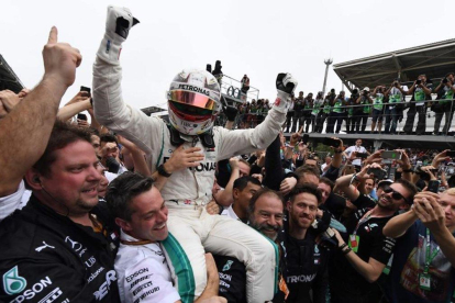 Hamilton es elevado por los mecánicos de Mercedes