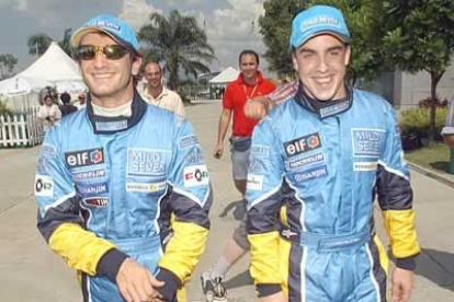 Alonso, a la derecha, camina junto a su compañero, el italiano Jarno Trulli.