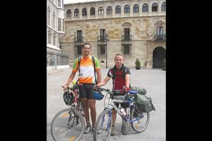 Juan y Juanjo posan con sus bicicletas frente al Palacio de los Guzmanes.