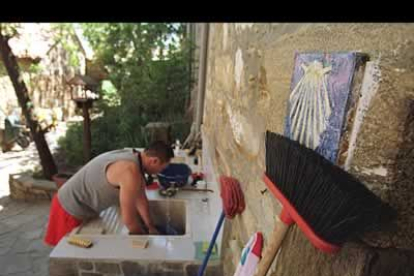 Un hombre lava su ropa en uno de los albergues que la provincia de León ofrece a los peregrinos.
