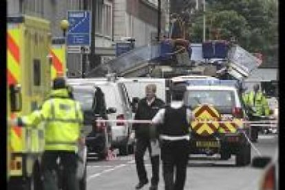 Personal de los servicios de emergencia trabajan en las cercanías de los restos del bus que explotó en Tavistock Square, en Londres.