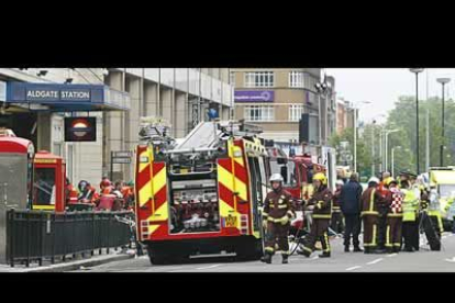 Policías y bomberos trabajan en las afueras de la estación de metro Aldgate East.