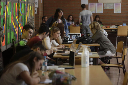 Alumnos de la Universidad de León, en una de sus facultades, aprovechan el vestíbulo para trabajar en equipo y repasar algunas materias. FERNANDO OTERO