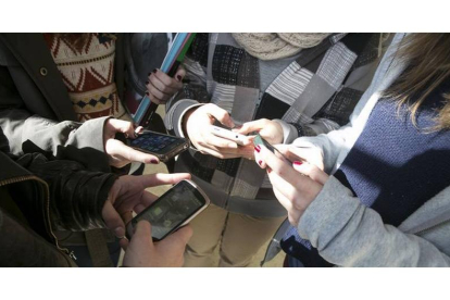 Un grupo de menores, con sus teléfonos móviles.