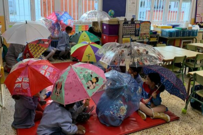 Alumnos del San Claudio con paraguas en clase. DL