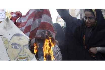 Una mujer quema una bandera estadounidense frente al edificio de la antigua embajada de EEUU, el 2 de noviembre del 2012.