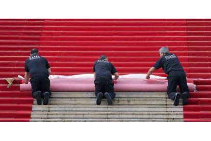 Trabajadores colocan la alfombra roja sobre la escalinata del Palacio de Festivales. Foto: EFE