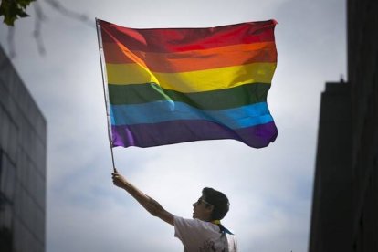 Un hombre sostiene la bandera gay del arcoiris en una marcha en San Francisco, Estados Unidos.