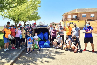 Imagen de los voluntarios con la basura recogida este sábado en Laguna de Negrillos. DL