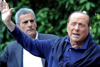 Berlusconi (derecha), al salir del hospital tras operarse del corazón, en Milán, el 5 de julio del 2016.