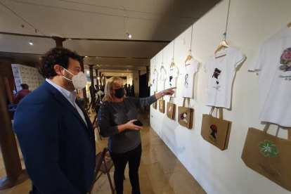 La concejala de Mujer Carmen Oláiz muestra al alcalde de Villaquilambre objetos de la exposición. DL