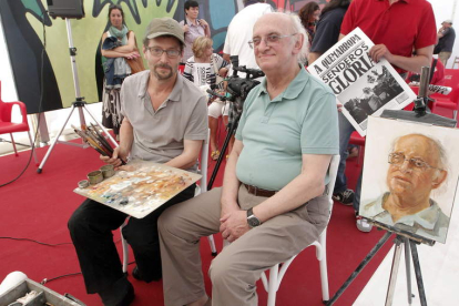 El artista leonés Félix de la Concha junto al escritor griego Petros Márkaris y el retrato del creador del comisario Jaritos.