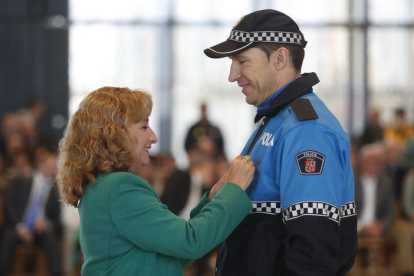 Ana del Ser pone la insignia a un policñia