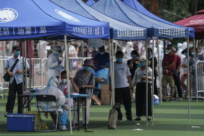 Residentes o gente que visitó el mercado de Xinfadi hacen cola para hacerse el test de coronavirus. STRINGER
