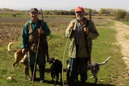 Dos cazadores muestran una de las liebres abatidas durante la jornada cinegética .