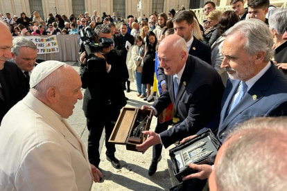 Gregorio Chamorro entrega al Papa un recuerdo con la imagen del guerrero de la Diputación que guarda la puerta de entrada al Claustro, mientras que Manolo Carnero le da una réplica de la Catedral de León. DL